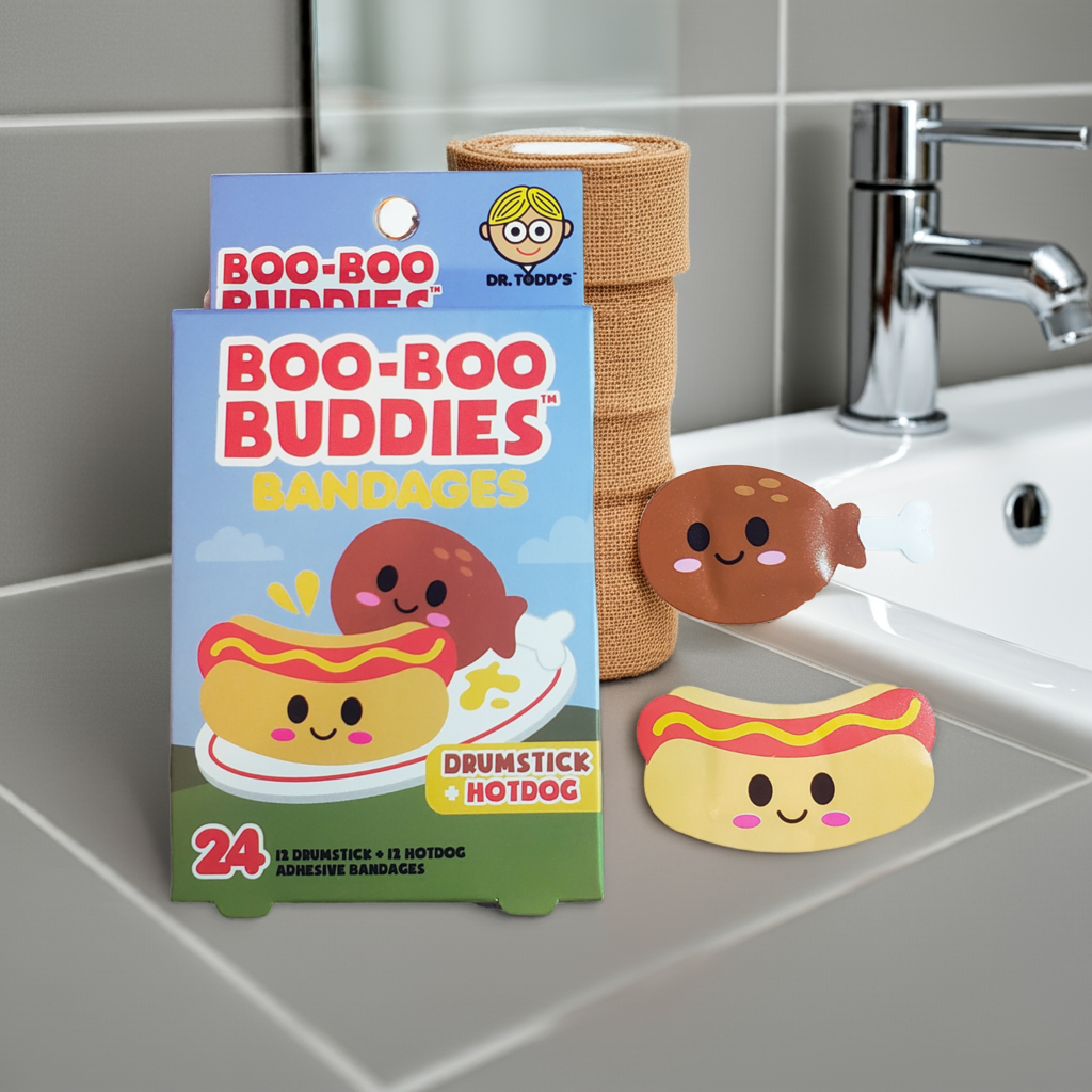 Boo Boo Buddies Drumstick and Hotdog bandages displayed by bathroom sink, fun food-themed waterproof bandaids for kids’ everyday comfort.